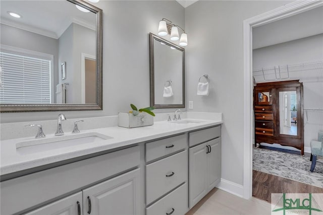 bathroom featuring vanity, crown molding, and hardwood / wood-style flooring