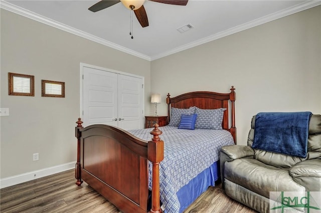 bedroom with hardwood / wood-style flooring, ceiling fan, ornamental molding, and a closet