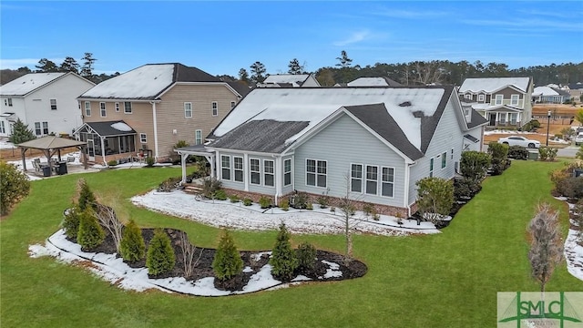 rear view of house featuring a gazebo and a yard