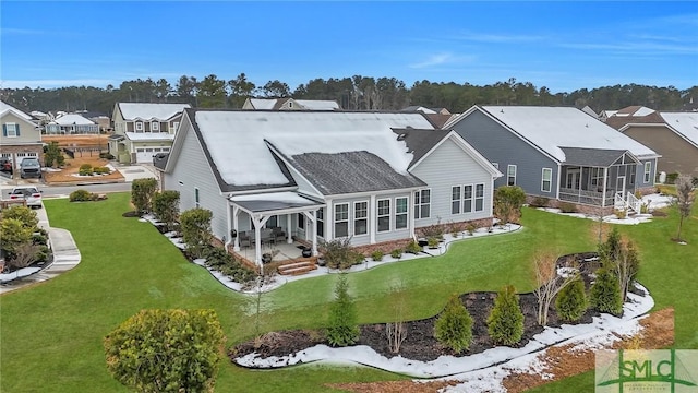 rear view of property with a sunroom and a yard