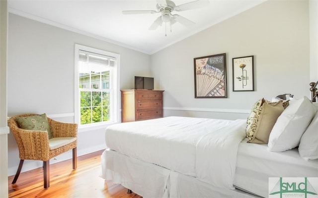 bedroom with hardwood / wood-style flooring, ornamental molding, lofted ceiling, and ceiling fan