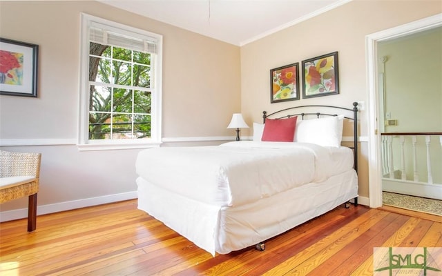 bedroom with ornamental molding and light hardwood / wood-style flooring