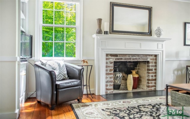 sitting room with a fireplace and hardwood / wood-style floors