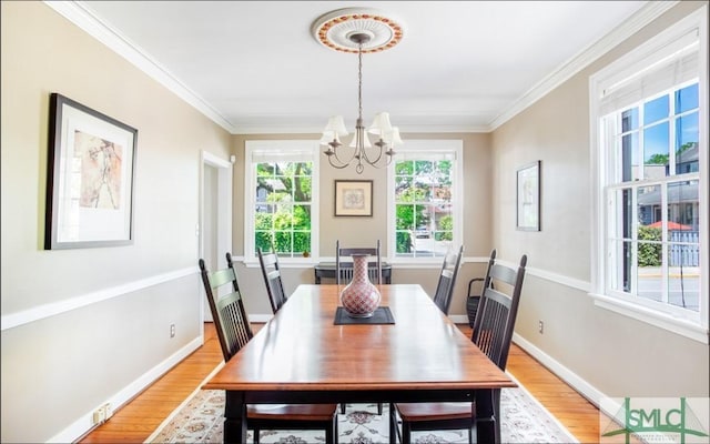 dining area with an inviting chandelier, light hardwood / wood-style flooring, and ornamental molding