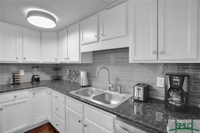 kitchen featuring tasteful backsplash, dishwasher, sink, white cabinets, and dark stone counters