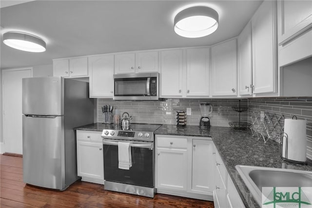 kitchen with backsplash, stainless steel appliances, dark hardwood / wood-style floors, and white cabinets