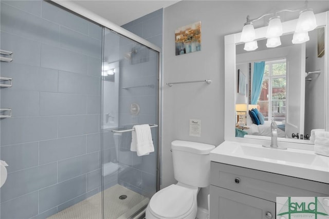 bathroom featuring vanity, an enclosed shower, and toilet