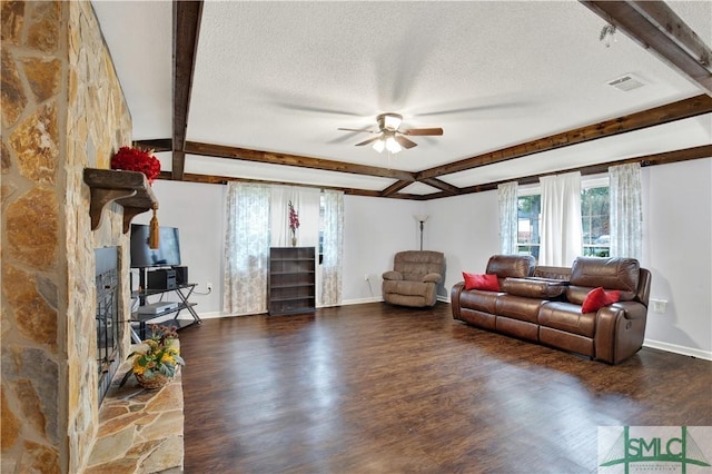 living room featuring beamed ceiling, ceiling fan, dark hardwood / wood-style floors, and a textured ceiling