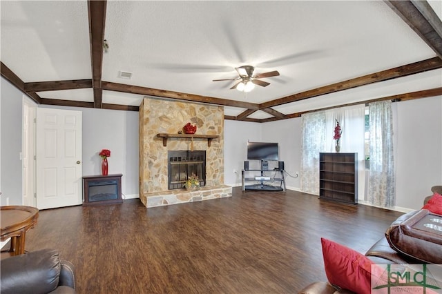 living room featuring beamed ceiling, ceiling fan, a stone fireplace, and hardwood / wood-style floors