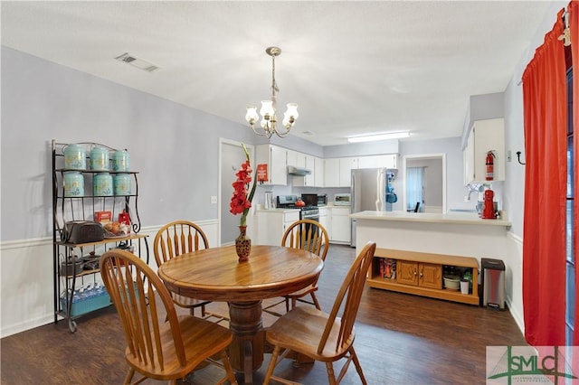 dining area with dark hardwood / wood-style flooring and a chandelier