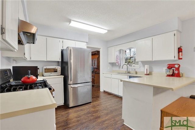 kitchen with white cabinetry, extractor fan, stainless steel refrigerator, and black gas range