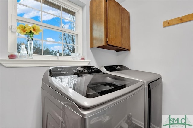 laundry room featuring cabinets and washing machine and clothes dryer