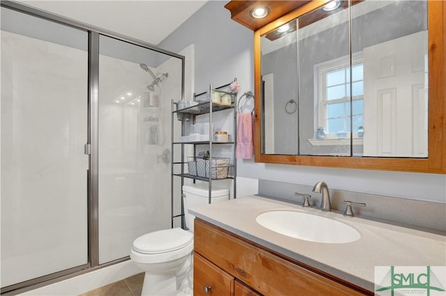 bathroom with vanity, toilet, tile patterned floors, and a shower with shower door