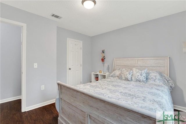 bedroom with dark hardwood / wood-style flooring and a textured ceiling