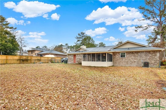 rear view of property with a sunroom and central AC unit