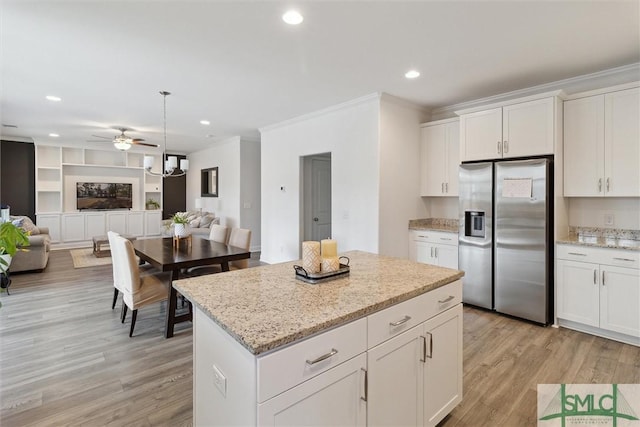 kitchen featuring pendant lighting, white cabinetry, stainless steel refrigerator with ice dispenser, light hardwood / wood-style floors, and a kitchen island