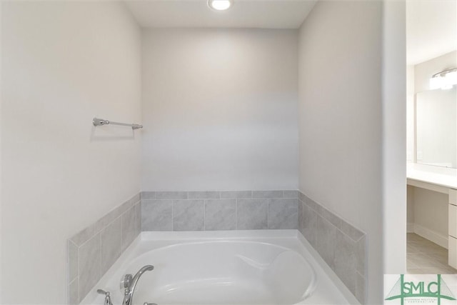 bathroom with tile patterned floors, vanity, and tiled tub