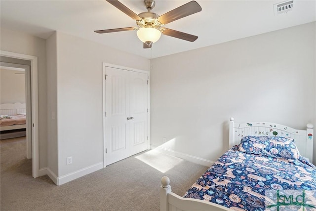 carpeted bedroom featuring ceiling fan and a closet