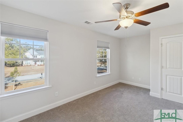 carpeted spare room with ceiling fan