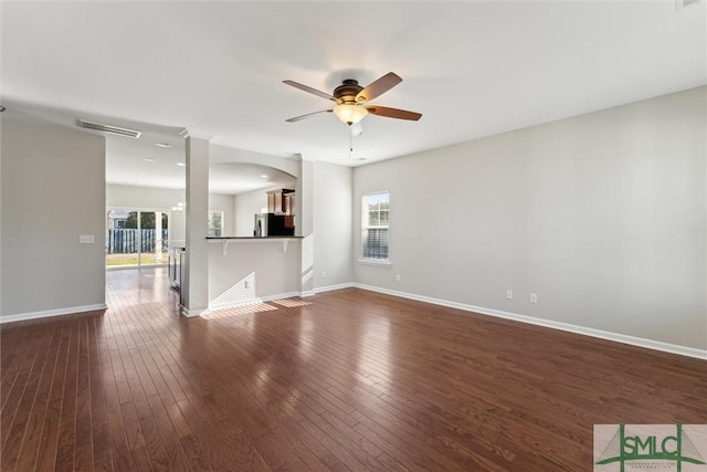 unfurnished living room with dark hardwood / wood-style floors, a wealth of natural light, and ceiling fan