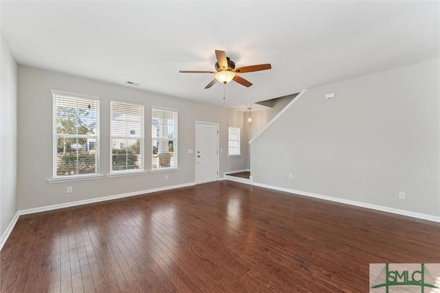 unfurnished living room featuring dark wood-type flooring and ceiling fan