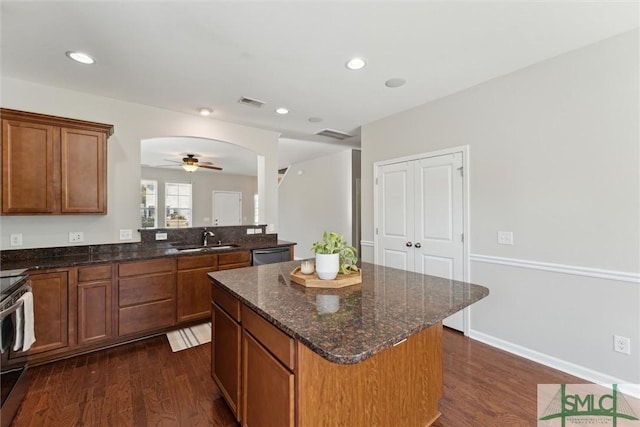 kitchen featuring stainless steel appliances, dark hardwood / wood-style flooring, sink, and a kitchen island