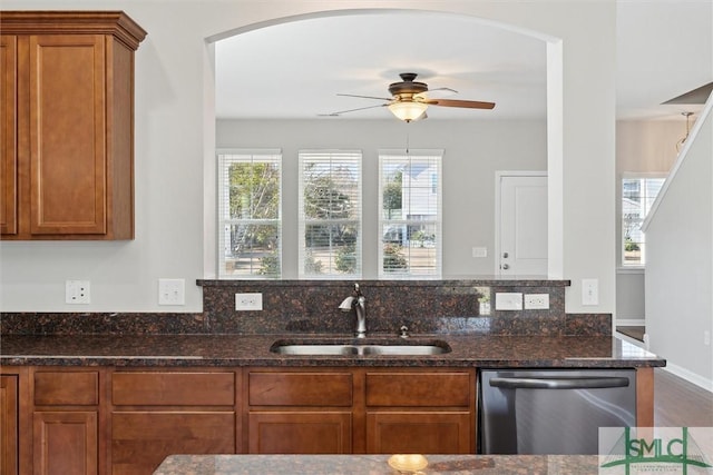 kitchen featuring dark stone countertops, sink, stainless steel dishwasher, and ceiling fan