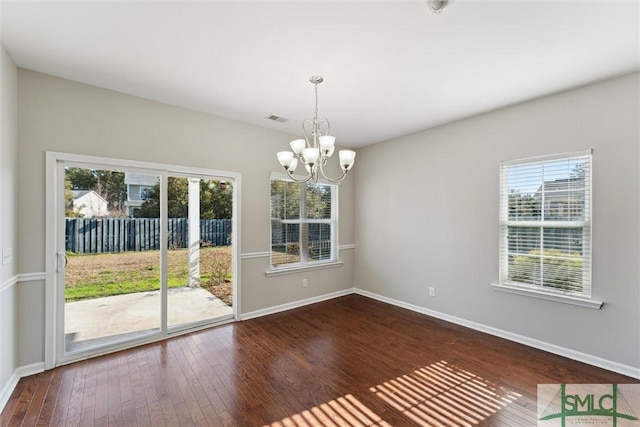 unfurnished dining area with a notable chandelier and wood-type flooring