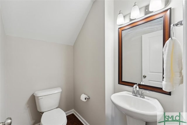 bathroom with sink, vaulted ceiling, and toilet