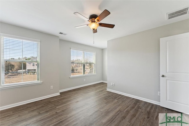 empty room with ceiling fan and dark hardwood / wood-style flooring