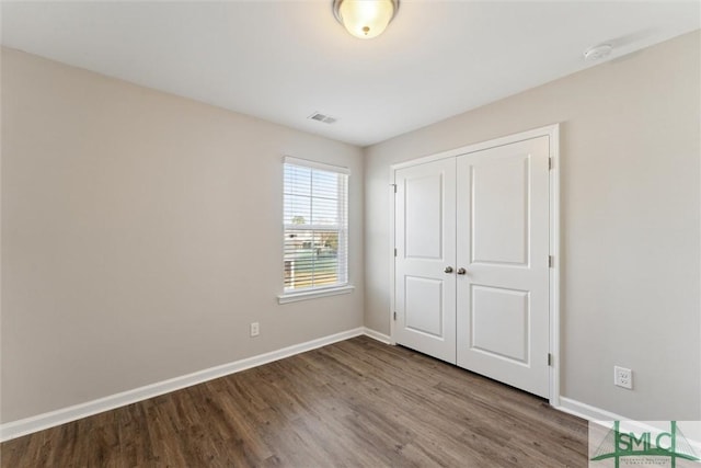 unfurnished bedroom featuring hardwood / wood-style floors and a closet