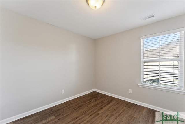 unfurnished room with dark hardwood / wood-style flooring