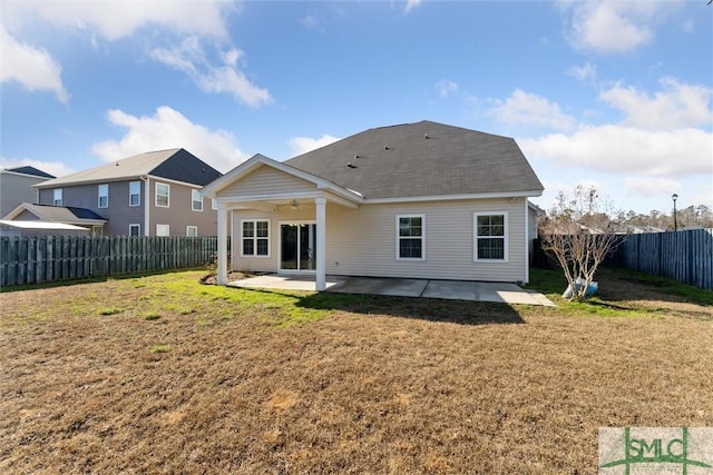 back of property with a yard, ceiling fan, and a patio area