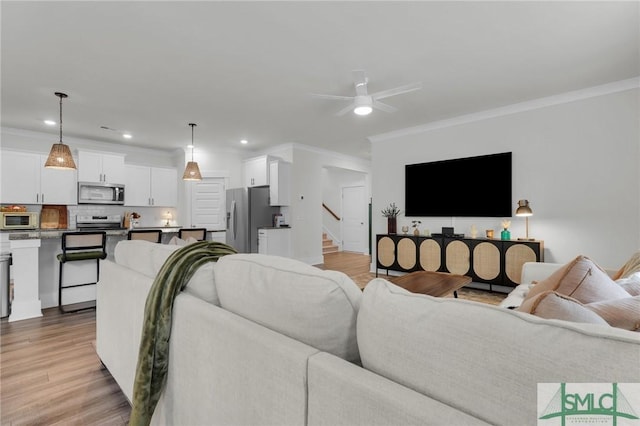 living area featuring light wood-type flooring and ornamental molding