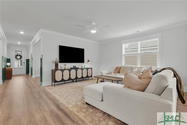 living area featuring a wealth of natural light, light wood-style floors, ceiling fan, and crown molding