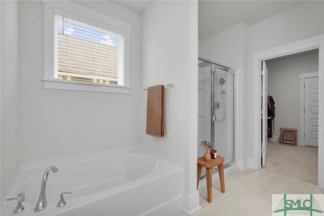 bathroom with a stall shower, a bath, and tile patterned flooring