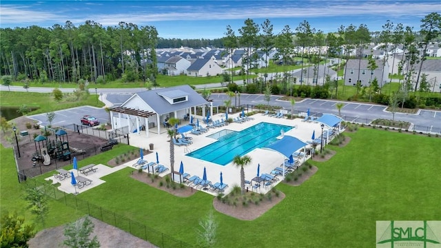 community pool with a residential view, a lawn, a patio, and fence