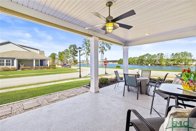 view of patio with a water view and ceiling fan