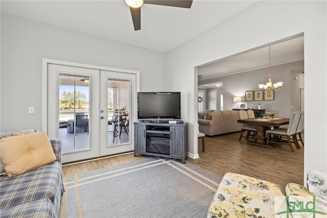 living room featuring french doors, ceiling fan with notable chandelier, and hardwood / wood-style floors