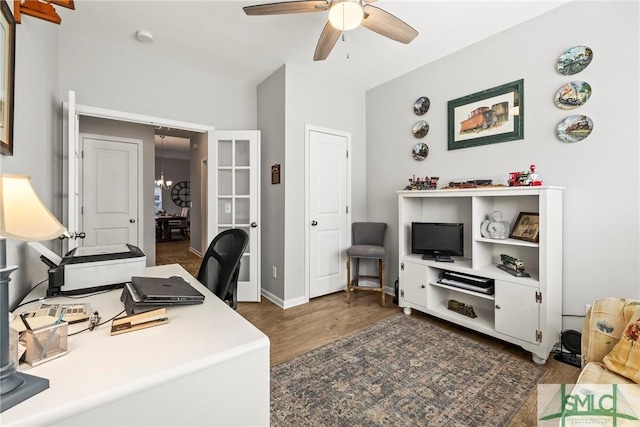 office space featuring ceiling fan with notable chandelier and dark wood-type flooring