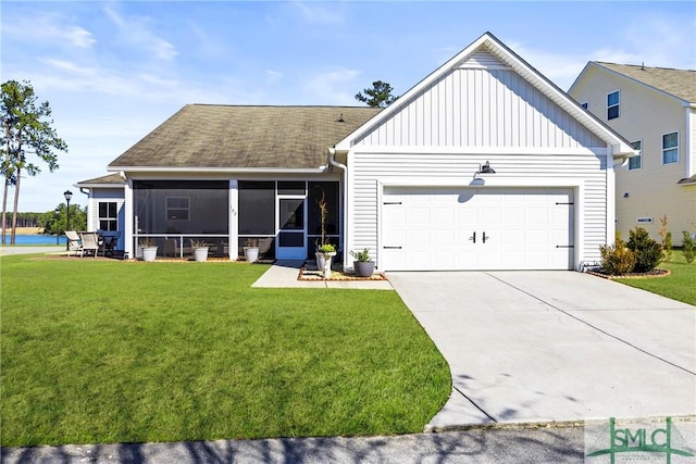 view of front of home featuring a garage, a front yard, and a sunroom