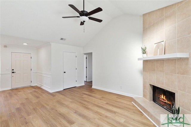 unfurnished living room with ceiling fan, a fireplace, high vaulted ceiling, and light hardwood / wood-style flooring