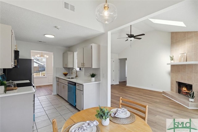 kitchen featuring white cabinetry, dishwasher, sink, and hanging light fixtures