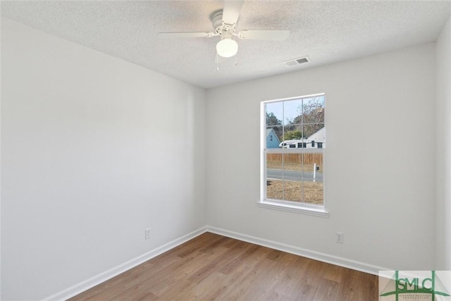 unfurnished room featuring ceiling fan, light hardwood / wood-style floors, and a textured ceiling