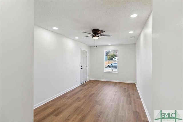 spare room featuring ceiling fan, a textured ceiling, and light hardwood / wood-style flooring