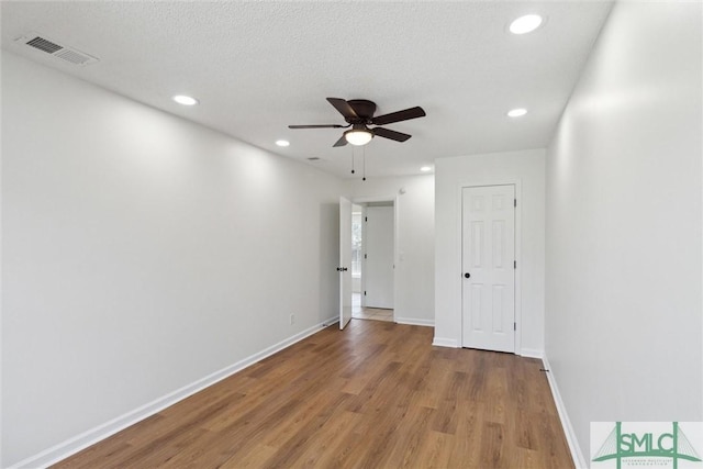 empty room featuring hardwood / wood-style floors, a textured ceiling, and ceiling fan