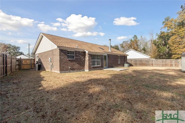 rear view of house with a lawn and a patio