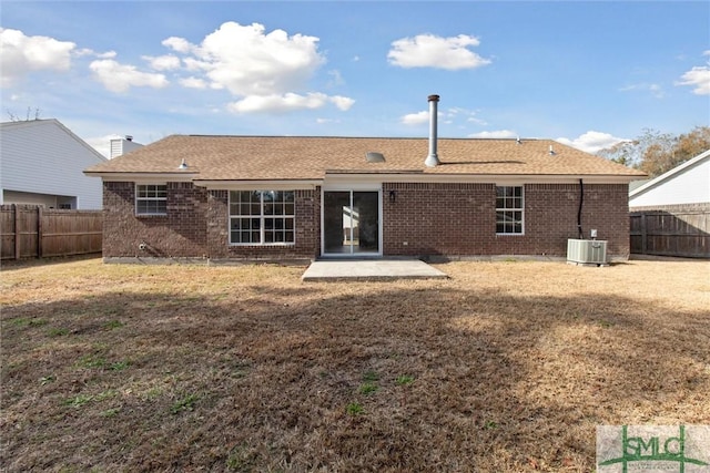 rear view of property with central air condition unit, a patio, and a lawn