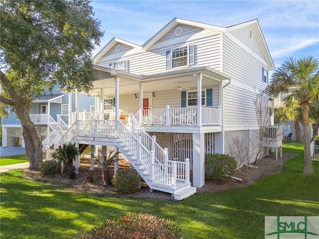 view of front of home with ceiling fan, a front yard, and covered porch