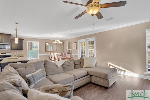 living room featuring dark hardwood / wood-style flooring, sink, ceiling fan with notable chandelier, and ornamental molding